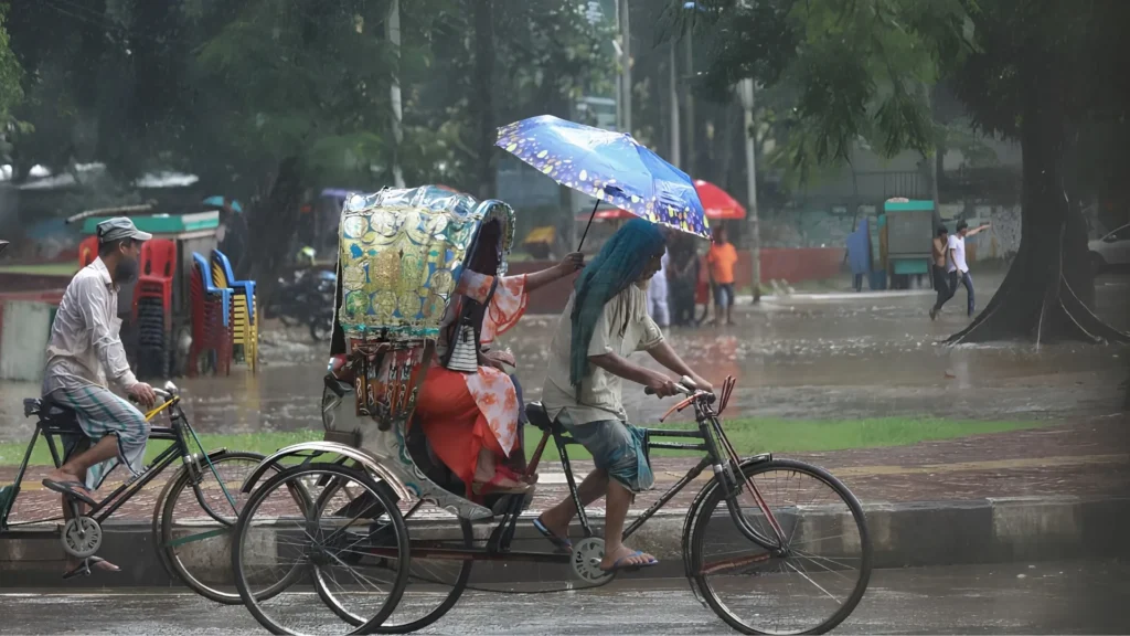 Rickshaw driver cycling in heavy monsoon rain
